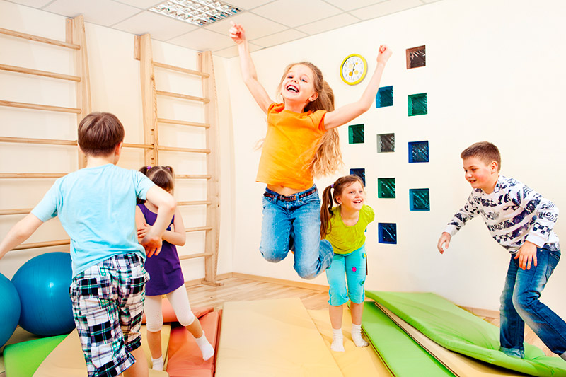 Kinder hüpfen und springen im Sportraum